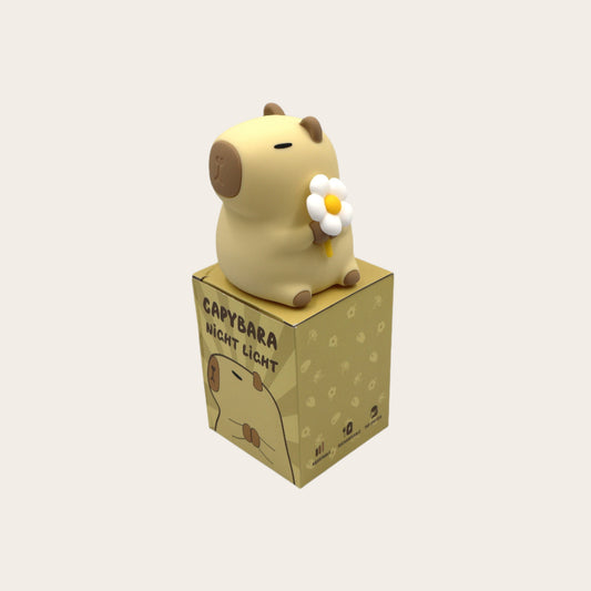 Cute capybara holding a flower night light on a box 