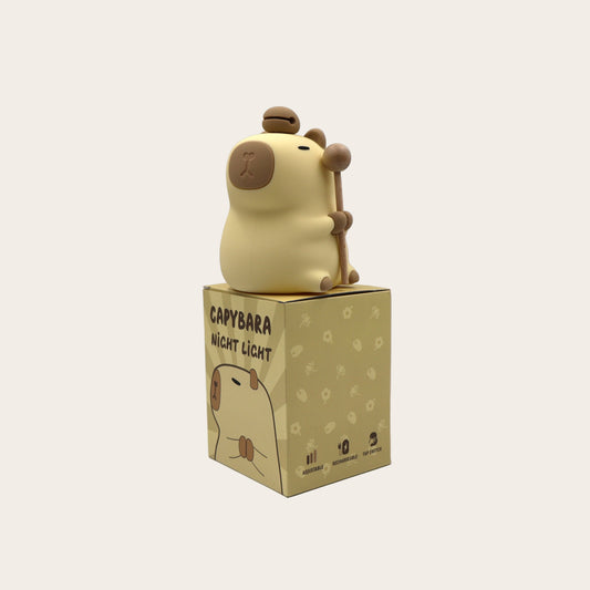 Capybara night light on top of its packaging box against a grey background