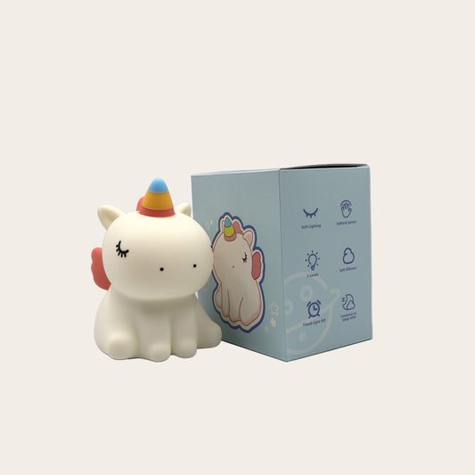 White unicorn night light with a blue box on a white background